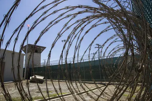 In this April 17, 2019, photo, reviewed by U.S. military officials, the control tower is seen through the razor wire inside the Camp VI detention facility in Guantanamo Bay Naval Base, Cuba. (AP Photo/Alex Brandon, File)