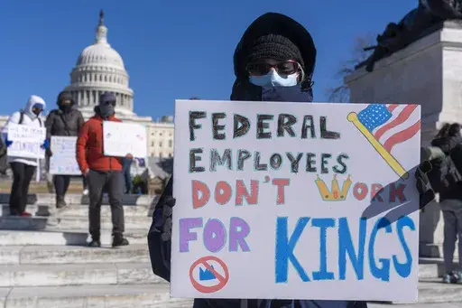 A federal employee, who asked not to use their name for fears over losing their job, protests with a sign saying "Federal Employees Don't Work for Kings" during the "No Kings Day" protest on Presidents Day in Washington, in support of federal workers and against recent actions by President Donald Trump and Elon Musk, Feb. 17, 2025, by the Capitol in Washington. (AP Photo/Jacquelyn Martin, File)