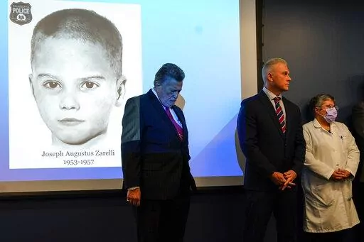William C. Fleisher, with the Vidocq Society, center, Philadelphia Police Captain Jason Smith, and Dr. Constance DiAngelo, Philadelphia Chief Medical Examiner, listen during during a news conference in Philadelphia, Thursday, Dec. 8, 2022. Nearly 66 years after the battered body of a young boy was found stuffed inside a cardboard box, Philadelphia police have revealed the identity of the victim in the city's most notorious cold case. Police identified the boy as Joseph Augustus Zarelli. (AP Phot