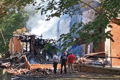 Lafayette County Fire Chief Wes Anderson, right, and county firefighters inspect the aftermath of a fire at College Hill Presbyterian Church near Oxford, Miss., Sunday morning, Aug. 14, 2022, after a Saturday night fire destroyed the majority of the historical structure. The church which was built in 1844, is where William Faulkner and his wife, Estelle, were married in 1929 — two decades before the novelist received the Nobel Prize in literature. (Maya Martin/The Oxford Eagle via AP)