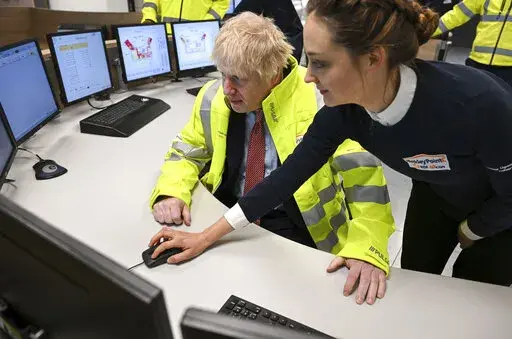 Britain's Prime Minister Boris Johnson meets staff in the control center training area during a visit to Hinkley Point C nuclear power station construction site in Somerset, England, Thursday, April 7, 2022. Britain plans to build eight new nuclear reactors and expand production of wind energy as it seeks to reduce dependence on oil and natural gas from Russia and other foreign suppliers following the invasion of Ukraine. (Finnbarr Webster/Pool Photo via AP)
