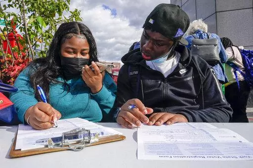 Residents of the Flatbush neighborhood of the Brooklyn borough of New York register to vote at a voter registration event on Sept. 29, 2021. New York's governor has signed a law intended to prevent local officials from enacting rules that might suppress people's voting rights because of their race. The law signed by Gov. Kathy Hochul, Monday, June 20, 2022, will make New York one of the first states to bring back a version of a process known as "preclearance." (AP Photo/Mary Altaffer, File)
