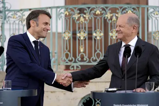 German Chancellor Olaf Scholz, right, and French President Emmanuel Macron shake hands during a press conference at the German government guest house in Meseberg, north of Berlin, Germany, on May 28, 2024. The German government has expressed concern about a possible victory of the far-right National Rally in France. Chancellor Scholz and many ordinary Germans fears that if the the nationalist French party gets elected on Sunday, it would no longer support the close and unique relationship betwee
