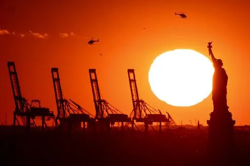 Container cranes at a port in New Jersey appear behind the Statue of Liberty, Sunday, Nov. 20, 2022, in New York. The global economy will come "perilously close" to a recession this year, led by weaker growth in all the world's top economies — the United States, Europe and China — the World Bank warned Tuesday.(AP Photo/Julia Nikhinson, File)