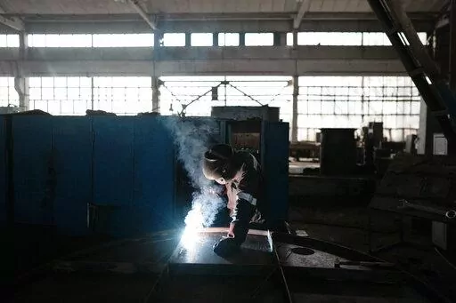 A worker welds part of a shelter in a plant of the Metinvest company, in Kryvyi Rih, Ukraine, Thursday, March 2, 2023. The plant, which is part of Renat Akhmetov's Metinvest metals and mining holding, ships metal shelters to the frontline. (AP Photo/Thibault Camus)