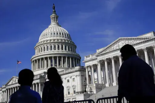 People walk outside the U.S Capitol building in Washington, June 9, 2022. A Democratic economic package focused on climate and health care faces hurdles but seems headed toward party-line passage by Congress next month. Approval would let President Joe Biden and his party claim a triumph on top priorities just as November’s elections approach. . (AP Photo/Patrick Semansky, File)