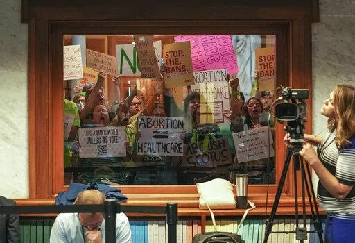 Demonstrators protest outside the Senate chambers before the start of special session Saturday, July 30, 2022, at the Indiana Statehouse in Indianapolis. Indiana state senators narrowly passed a near-total abortion ban Saturday during a rare weekend session, sending the bill to the House after a contentious week of arguments over whether to allow exceptions for rape and incest. (Jenna Watson/The Indianapolis Star via AP)