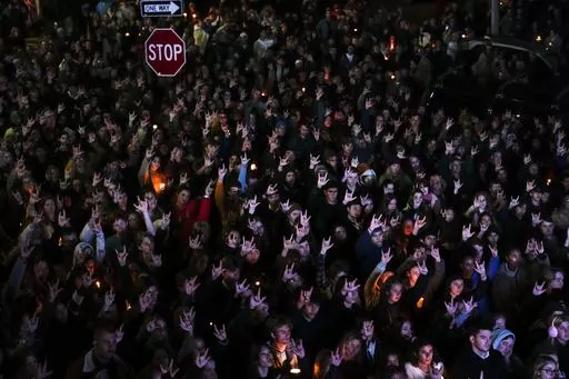 People sign "I love you," while gathered at a vigil for the victims of mass shootings days earlier, Sunday, Oct. 29, 2023, outside the Basilica of Saints Peter and Paul in Lewiston, Maine. Two senators from Maine are asking the U.S. Army inspector general to provide a full accounting of interactions with a reservist before he killed multiple people at a bowling alley and bar. (AP Photo/Matt Rourke, File)