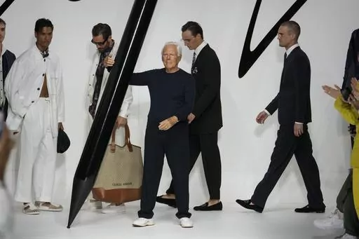 Designer Giorgio Armani receives applause at the end of the Giorgio Armani men's Spring Summer 2024 fashion show presented in Milan, Italy, Monday, June 19, 2023. (AP Photo/Luca Bruno)