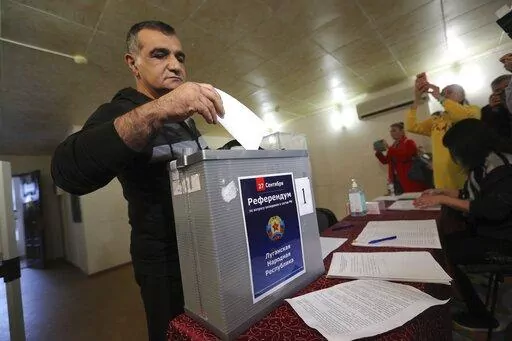 A man from Luhansk region, the territory controlled by a pro-Russia separatist government, but who lives in Russia, votes at temporary accommodation facility in Volgograd, Russia, Friday, Sept. 23, 2022. Voting began Friday in four Moscow-held regions of Ukraine on referendums to become part of Russia. Polls also opened in Russia, where refugees from regions under Russian control can cast their votes.  (AP Photo)
