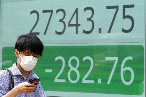 A person wearing a protective mask walks past an electronic stock board showing Japan's Nikkei 225 index at a securities firm Wednesday, Sept. 7, 2022, in Tokyo. Asian shares were mostly lower Wednesday, as pessimism prevailed about higher interest rates ahead and Wall Street shares fell for the fourth straight week. Oil prices fell, while the Japanese yen continued to decline against the U.S. dollar to nearly 144 yen. (AP Photo/Eugene Hoshiko)