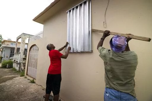 Residents prepare for the arrival of Tropical Storm Fiona, in Loiza, Puerto Rico, Saturday, Sept. 17, 2022. Fiona was expected to become a hurricane as it neared Puerto Rico on Saturday, threatening to dump up to 20 inches (51 centimeters) of rain as people braced for potential landslides, severe flooding and power outages. (AP Photo/Alejandro Granadillo)
