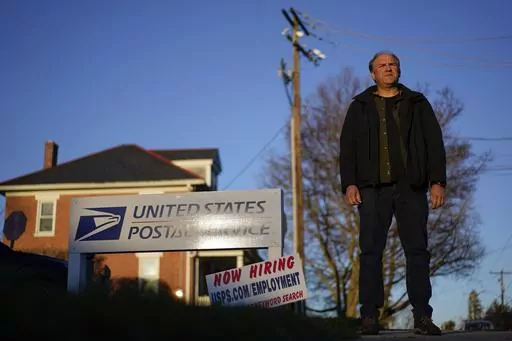 Gerald Groff, a former postal worker whose case will be argued before the Supreme Court, stands during a television interview near a "Now Hiring" sign posted at the roadside at the United State Postal Service, March 8, 2023, in Quarryville, Pa. The Supreme Court on Thursday, June 29, used the case of a Christian mailman who didn't want to work Sundays to solidify protections for workers who are religious. In a unanimous decision the justices made clear that workers who ask for religious accommod