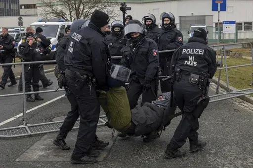 Police officers remove a protestor from the street during a demonstration ahead of the AfD's national party conference, in Riesa, Germany, Saturday, Jan. 11, 2025. (Daniel Wagner/dpa via AP)