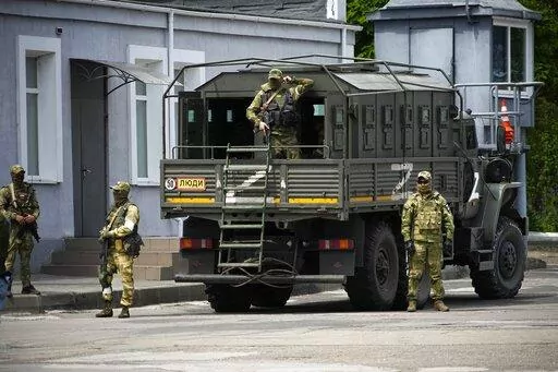 Russian soldiers guard an area as a group of foreign journalists visit in Kherson, Kherson region, south Ukraine, May 20, 2022. Russia’s military has announced that it’s withdrawing from Ukraine's southern city of Kherson and nearby areas. That would be another in a series of humiliating setbacks for Moscow’s forces in the 8-month-old war. This photo was taken during a trip organized by the Russian Ministry of Defense. (AP Photo, File)