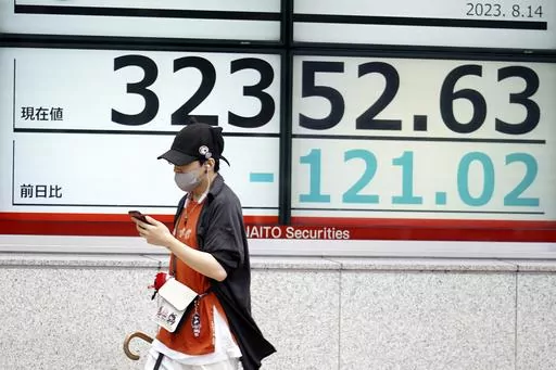 A person walks in front of an electronic stock board showing Japan's Nikkei 225 index at a securities firm Monday, Aug. 14, 2023, in Tokyo. Asian stock markets tumbled Monday after mixed U.S. economic data revived worries the Federal Reserve might hike interest rates again. (AP Photo/Eugene Hoshiko)