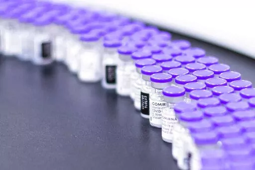 In this March 2021 photo provided by Pfizer, vials of the Pfizer-BioNTech COVID-19 vaccine are prepared for packaging at the company's facility in Puurs, Belgium. According to a study published Thursday. June 23, 2022 in the journal Lancet Infectious Diseases, nearly 20 million lives were saved by COVID-19 vaccines during their first year, but even more deaths could have been prevented if global targets had been reached. (Pfizer via AP)