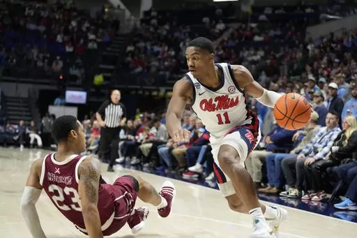 Mississippi guard Matthew Murrell (11) dribbles past falling Troy guard Aamer Muhammad (23) during the first half of an NCAA college basketball game Tuesday, Dec. 19, 2023, in Oxford, Miss. (AP Photo/Rogelio V. Solis)