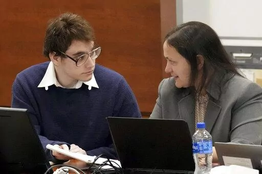 Marjory Stoneman Douglas High School shooter Nikolas Cruz speaks with sentence mitigation specialist Kate O'Shea, a member of the defense team, during jury instructions in the penalty phase of Cruz's trial at the Broward County Courthouse in Fort Lauderdale, Fla. on Wednesday, Oct. 12, 2022. Cruz previously plead guilty to all 17 counts of premeditated murder and 17 counts of attempted murder in the 2018 shootings. (Amy Beth Bennett/South Florida Sun Sentinel via AP, Pool)