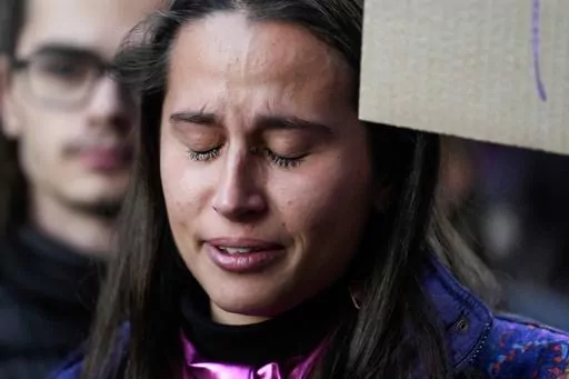 A student cries during a flash mob 'A minute of noise for Giulia' for Giulia Cecchettin, allegedly killed at the hands of her possessive ex-boyfriend, outside the Statale University, in Milan, Italy, Wednesday, Nov. 22, 2023. Outrage over violence against women is mounting in Italy, with students leading the way. Young people across the country have taken to pounding on classroom desks in unison to demand an end to the slayings of women by men and to root out corrosive, patriarchal attitudes tha