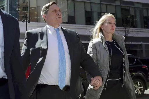 John Wilson arrives at federal court, with his wife Leslie, on April 3, 2019 to face charges in a nationwide college admissions bribery scandal in Boston. Wilson, a former Staples Inc. executive who was convicted of trying to bribe his children's way into USC, Harvard and Stanford, is scheduled to be sentenced on federal charges Wednesday Feb. 16, 2022. (AP Photo/Charles Krupa, File)