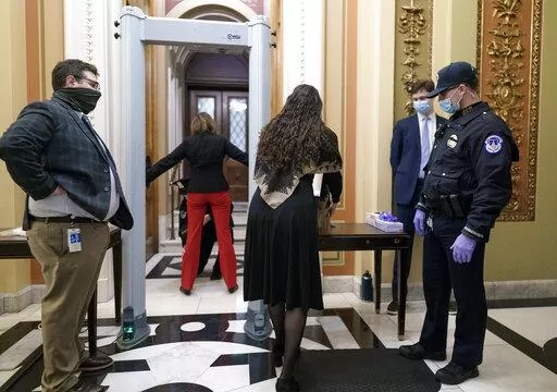 Congressional staff passes through a metal detector and security screening as they enter the House chamber, new measures put into place after a violent mob loyal to President Donald Trump stormed the Capitol, in Washington, Jan. 12, 2021. (AP Photo/J. Scott Applewhite, File)