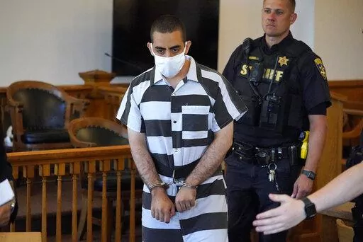 Hadi Matar, 24, center, arrives for an arraignment in the Chautauqua County Courthouse in Mayville, N.Y., Saturday, Aug. 13, 2022. Matar, who is accused of carrying out a stabbing attack against “Satanic Verses” author Salman Rushdie has entered a not-guilty plea in a New York court on charges of attempted murder and assault. An attorney for Matar entered the plea on his behalf during an arraignment hearing.  (AP Photo/Gene J. Puskar)
