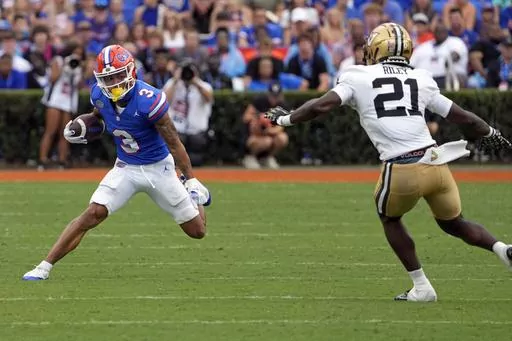 Florida wide receiver Eugene Wilson III (3) looks for a way around Vanderbilt safety Savion Riley (21) after a reception during the first half of an NCAA college football game, Saturday, Oct. 7, 2023, in Gainesville, Fla. (AP Photo/John Raoux)