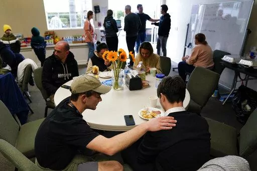 Volunteer Silas Breen, below left, from the Calvary Bible Institute, prays with David, from Ukraine, at San Diego Calvary's shelter for Ukrainians arriving after crossing into the United States from Tijuana, Mexico, Friday, April 1, 2022, in Chula Vista, Calif. As U.S. refugee resettlement agencies and nonprofits nationwide gear up to help Ukrainians fleeing the Russian invasion and war that has raged for nearly six weeks, members of faith communities have been leading the charge to welcome the 