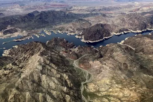 In this aerial photo, a bathtub ring of light minerals show the high water mark on the shore of Lake Mead along the border of Nevada and Arizona, Monday, March 6, 2023, near Boulder City, Nev. The federal government is expected to make an announcement on Tuesday, Aug. 15, 2023, about the health of the Colorado River and water cuts in 2024. (AP Photo/John Locher,File)