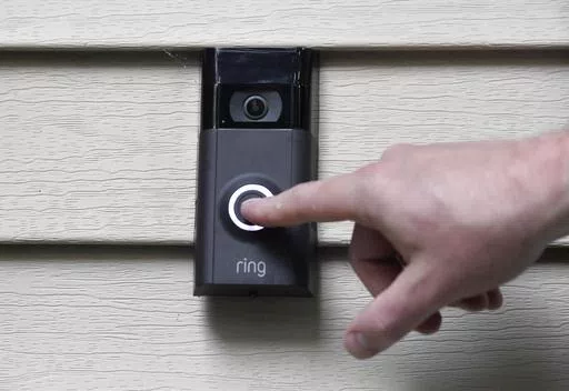 A person pushes the doorbell on his Ring doorbell camera, July 16, 2019, at his home in Wolcott, Conn. The Federal Trade Commission is sending $5.6 million in refunds to consumers as part of a settlement with Amazon-owned Ring, which was charged with failing to protect private video footage from outside access. (AP Photo/Jessica Hill, File)