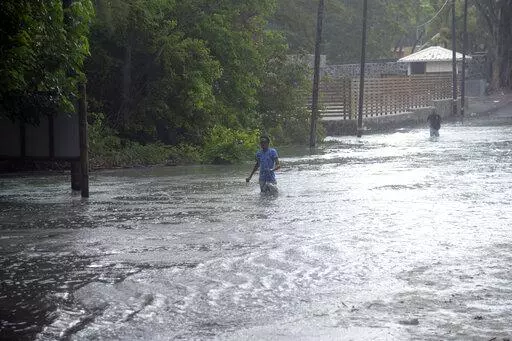 A man walks through a flooded road in the coast of the Indian Ocean Island of Mauritius Monday Feb. 20, 2023. Forecasts say Tropical Cyclone Freddy is increasing in intensity and is expected to pass north of the Indian Ocean island nation of Mauritius and make landfall in central Madagascar Tuesday evening.It's feared that up to 2.2 million people, mostly in Madagascar, will be impacted by storm surges and flooding, according to the Global Disaster Alert and Coordination System.(AP Photo/L'expre
