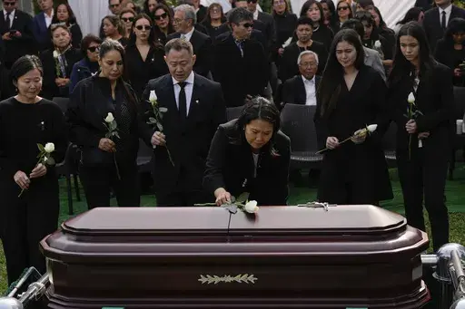 Keiko Fujimori places a flower over the coffin of her father, former President Alberto Fujimori, in Lima, Peru, Saturday, Sept. 14, 2024. (AP Photo/Guadalupe Pardo)
