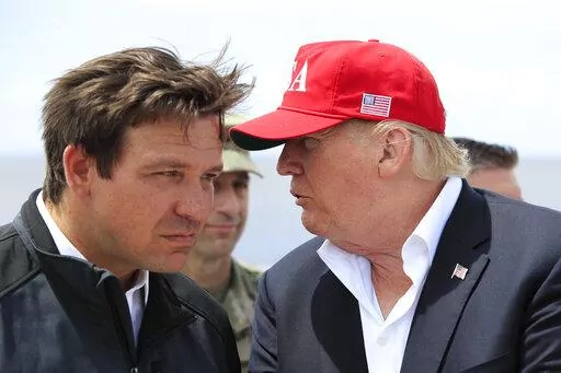 President Donald Trump talks to Florida Gov. Ron DeSantis, left, during a visit to Lake Okeechobee and Herbert Hoover Dike at Canal Point, Fla., March 29, 2019. Republican 2024 presidential prospects descend upon Las Vegas this weekend as anxious donors and activists openly consider whether to embrace former President Donald Trump for a third consecutive run for president. Trump will be among the only major Republican prospects not in attendance for the Republican Jewish Coalition’s annual lea