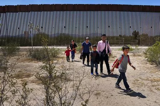 A family of five claiming to be from Guatemala and a man stating he was from Peru, in pink shirt, walk through the desert after crossing the border wall in the Tucson Sector of the U.S.-Mexico border, Tuesday, Aug. 29, 2023, in Organ Pipe Cactus National Monument near Lukeville, Ariz. U.S. Customs and Border Protection reports that the Tucson Sector is the busiest area of the border since 2008 due to smugglers abruptly steering migrants from Africa, Asia and other places through some of the Ariz