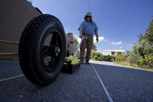 Harry M. Jol, a geography and anthropology professor at the University of Wisconsin Eau Claire, operates a ground-penetrating radar in the village of Exo Metochi, Duzova, in the Turkish occupied area at breakaway Turkish Cypriot north of ethnically divided Cyprus on Tuesday, Sept. 5, 2023. Emitting radio waves, the machine is probing for any disturbances through layers of soil beneath the asphalt to offer any clues supporting eyewitness accounts that people who vanished nearly a half century ago