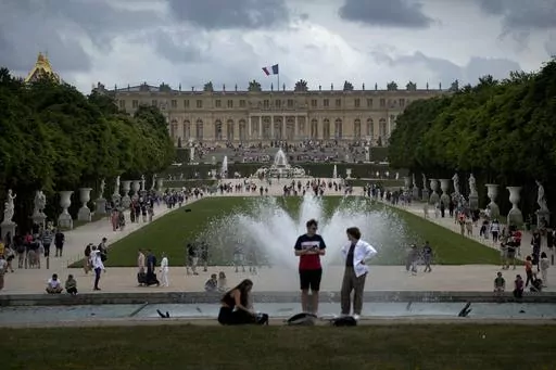 Visitors enjoy the Chateau de Versailles gardens, outside Paris, France, on July 15, 2023. France is rolling out the red carpet for King Charles III's state visit starting on Wednesday Sept. 20, 2023 at one of its most magnificent and emblematic monuments: the Palace of Versailles, which celebrates its 400th anniversary. (AP Photo/Christophe Ena, File)