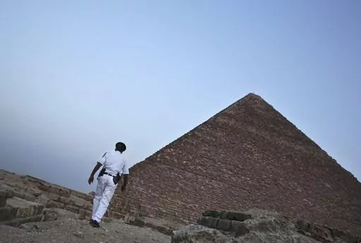 An Egyptian policeman walks near a pyramid in Giza, Egypt, on Nov. 9, 2015. A leading Egyptian opposition politician was targeted with spyware multiple times after announcing a presidential bid — including with malware that automatically infects smartphones, security researchers have found. They say Egyptian authorities were likely behind the attempted hacks. (AP Photo/Nariman El-Mofty, File)
