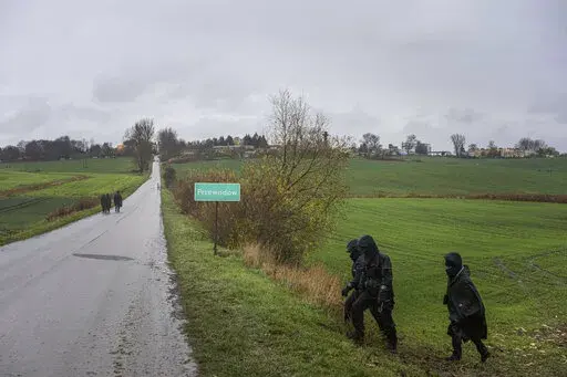 Polish police officers search for missile wreckage in the field, near the place where a missile struck, killing two people in a farmland at the Polish village of Przewodow, near the border with Ukraine, Wednesday, Nov. 16, 2022. (AP Photo/Evgeniy Maloletka)