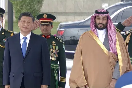 In this image taken from footage by Saudi State TV, Chinese President Xi Jinping, left, listens to the Chinese national anthem next to Saudi Crown Prince and Prime Minister Mohammed bin Salman in Riyadh, Saudi Arabia, Thursday, Dec. 8, 2022. (Saudi Press Agency via AP)