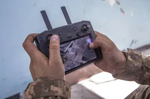 A Ukrainian soldier looks at a drone screen showing Russian troops positions during heavy fighting at the front line in Severodonetsk, Luhansk region, Ukraine, Wednesday, June 8, 2022. (AP Photo/Oleksandr Ratushniak)