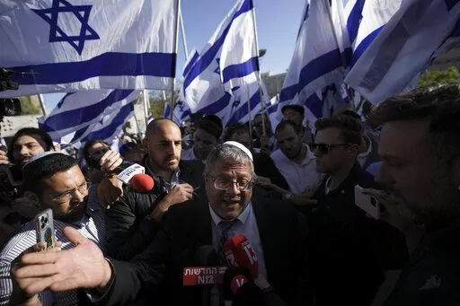 Israeli lawmaker Itamar Ben-Gvir, center, surrounded by right wing activists with Israeli flags, speaks to the media as they gather for a march in Jerusalem, Wednesday, April 20, 2022. Major Jewish American organizations, traditionally a bedrock of support for Israel, have expressed alarm over the presumptive government's far-right character. Given American Jews' predominantly liberal political views and affinity for the Democratic Party, these misgivings could have a ripple effect in Washington