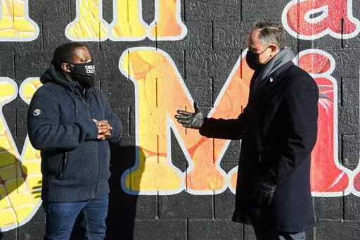 Second gentleman Doug Emhoff, the spouse of Vice President Kamala Harris, right, speaks with Christopher Bradshaw, executive director of Dreaming out Loud, a nonprofit organization focused on food security and economic opportunity, during a visit to Kelly Miller Middle School in Washington, on Jan. 28, 2021. (Nicholas Kamm/Pool via AP, File)