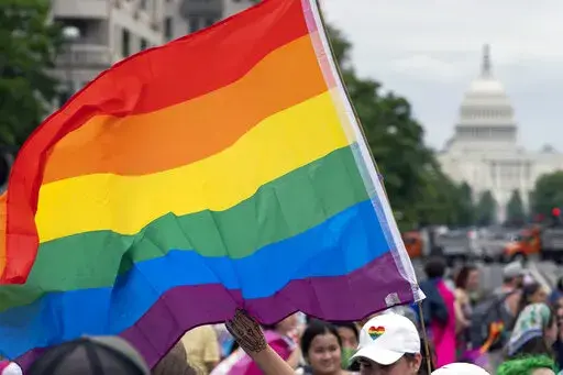With the U.S. Capitol in the background, a person waves a rainbow flag as they participant in a rally in support of the LGBTQIA+ community at Freedom Plaza, Saturday, June 12, 2021, in Washington. The U.S. House overwhelmingly approved legislation Tuesday, July, 19, 2022, to protect same-sex and interracial marriages amid concerns that the Supreme Court ruling overturning Roe v. Wade abortion access could jeopardize other rights criticized by many conservative Americans. (AP Photo/Jose Luis Maga