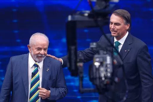 Brazil's former President Luiz Inacio Lula da Silva, who is running for office again, left, faces Jair Bolsonaro in a presidential debate at Bandeirantes Television in Sao Paulo, Brazil, Sunday, Oct. 16, 2022. The presidential runoff election is set for Oct. 30. (AP Photo/Marcelo Chello)