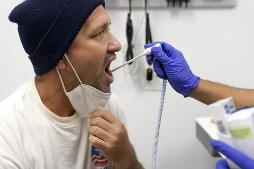 Julio Figuera, 43, has his temperature taken at the Cook County, Ill., medical clinic on Monday, Oct. 16, 2023, in Chicago. "I rarely get sick," he said. "It was the journey that got me sick." Figuera, developed pneumonia since arriving in the U.S. and has been living with hundreds of other asylum seekers at O'Hare International Airport while awaiting more city permanent shelter. When migrants began arriving in Chicago last year, city leaders tapped the county's health system to take over medica