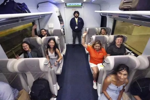 Passengers celebrate as the first Brightline train to Miami for the debut of service from Orlando International Airport pulls out of the station, early Friday, Sept. 22, 2023. The high-speed Orlando-Miami route marks first new privately-owned inter-city passenger service to roll out in the U.S. in 100 years. (Joe Burbank /Orlando Sentinel via AP)