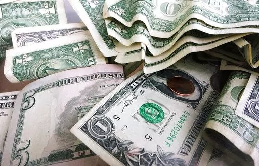 FILE- This Sept. 6, 2017, file photo shows a tip jar with one dollar and five dollar bills and a penny in New York. Millions of Americans deal with food, housing and general financial insecurity every year. Getting help can be tedious and time consuming, especially if you’re facing language barriers, don’t have reliable internet access or simply don’t have the bandwidth because you’re caring and providing for your family. Nonprofit organizations like 211.org and the National Low Income H