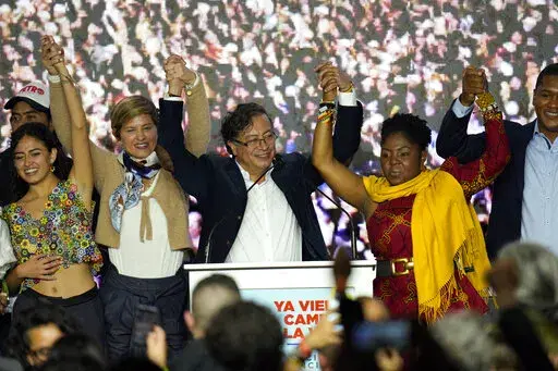 Presidential candidate Gustavo Petro, center, and his running mate Francia Marquez, at his right, with the Historical Pact coalition, stand before supporters with Marquez's wife Veronica Alcocer, second from left, and their daughter Andrea on election night in Bogota, Colombia, Sunday, May 29, 2022. Petro will advance to a runoff contest in June after none of the six candidates in Sunday's first round got half the vote. (AP Photo/Fernando Vergara)