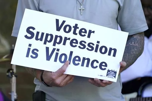 A person previously convicted of a felony felon holds a sign about voter suppression during a Poor People's Campaign assembly, April 19, 2021, in Jackson, Miss. A significant expansion of voting rights in Mississippi was put in doubt Thursday, Sept. 28, 2023, when a federal appeals court said it's reconsidering an earlier decision to allow people convicted of certain felonies to cast ballots. (AP Photo/Rogelio V. Solis, File)